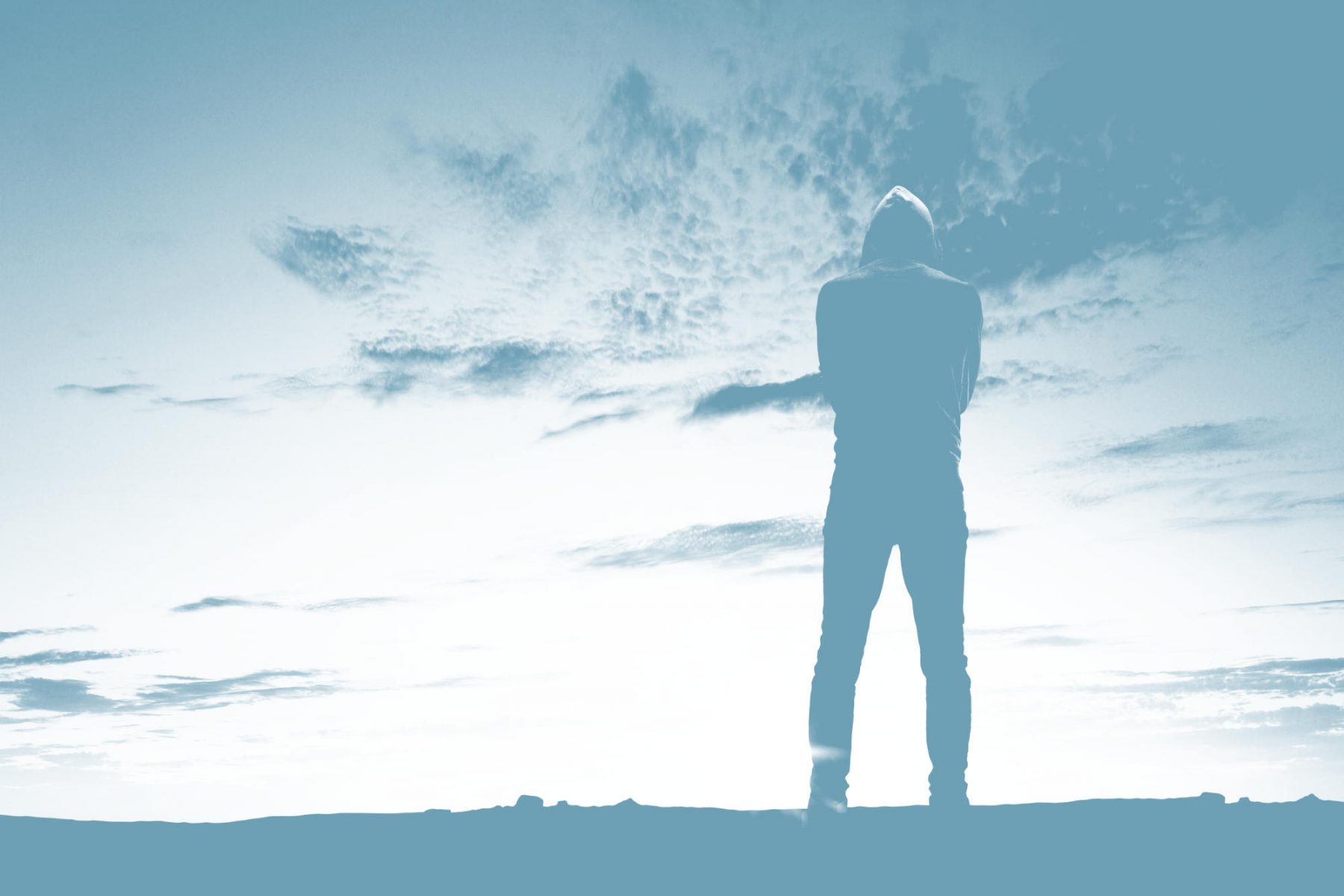 Distanz e.V. Titelbild: Junger Mann mit Kapuze steht mit dem Rücken zum Betrachter vor einem weiten Horizont.